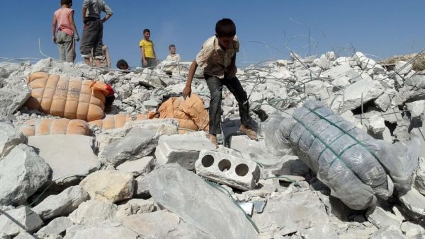 Young Syrians survey the damage from a regime airstrike. (AFP/File)