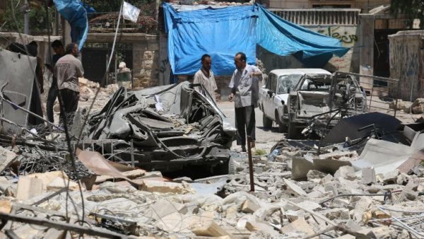 Syrian men look at the damage on June 13, 2016, following reported air strikes the previous night on the rebel-held neighborhood of al-Mashhad in the northern city of Aleppo. (AFP/Ameer al-Halbi)