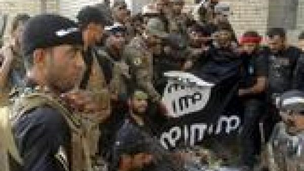 أفراد من قوات الأمن العراقية يحملون علم داعش بعدما أنزلوه من على جامعة الأنبار
