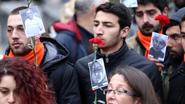 Demonstrators hold carnations and pictures of victims of Sunday's suicide bomb attack during a silent march to pay tributes to the victims, in Ankara, on March 15, 2016 in Ankara. (AFP/Adem Altan)