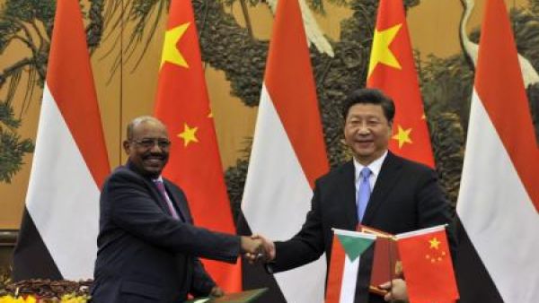 الرئيس الصيني شي جين بينغ (يمينا) يصافح نظيره السوداني عمر البشير في بكين يوم الثلاثاء
