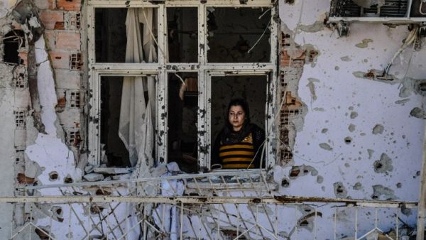 A woman looks through a window of her ruined house on March 8, 2016 during International Women`s day in Cizre district. (AFP/Ilyas Akengin)