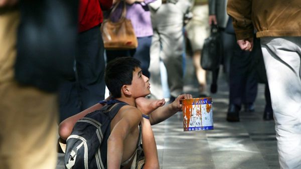 Beggar begs for alms from passersby along a street (AFP/File Photo)	