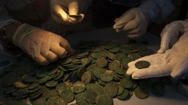 Experts look closely at the Roman coins. (AFP/ File Photo)