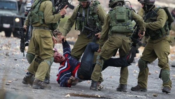 Israeli soldiers detain a Palestinian stone thrower near Beit El, on the outskirts of the West Bank city of Ramallah, on October 7, 2015. (AFP/Abbas Momani)