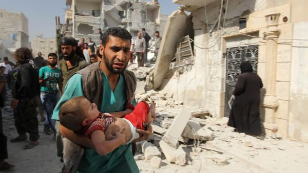 An medical worker carries a wounded child in Aleppo, Syria.  (AFP/Karam al-Masri)