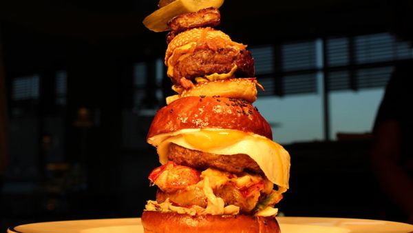 The Burger Khalifa is loaded with two beef patties, a Maine Lobster Tail, foie gras, black truffle aioli, and a sunny side egg. (Firebird Diner)