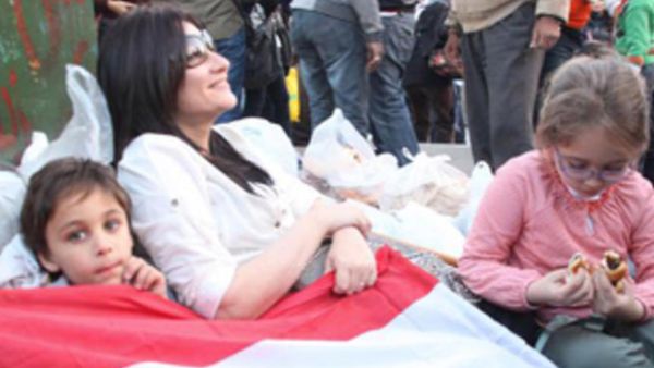 جيهان مع طفليها في ميدان التحرير في ثورة 25 يناير