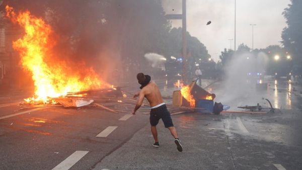 A protester throws a bottle at riot police in Hamburg last week. (Ronny Hartmann/ AFP)