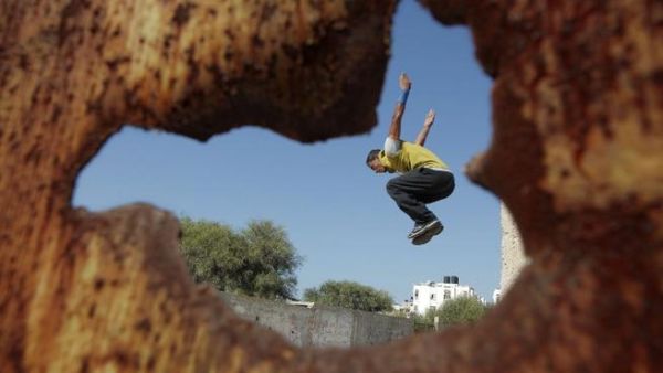 شاب من غزة يمارسة رياضة القفز على سور مهدم/أ.ف.ب