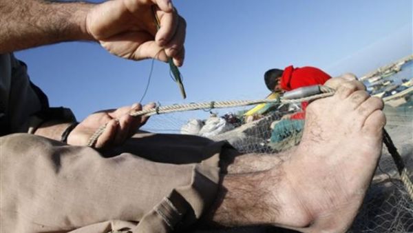 صياد فلسطيني يصلح شباكه على بحر رفح/أ.ف.ب