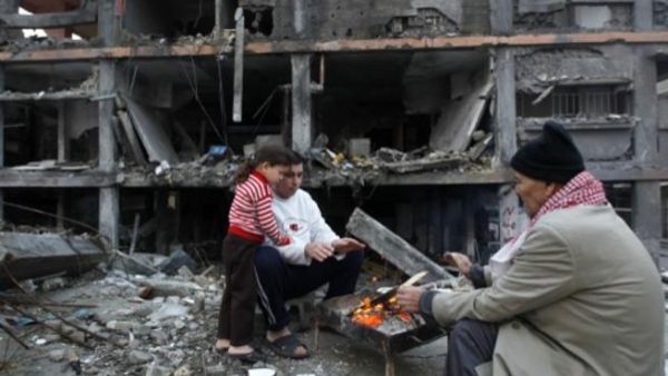 فلسطينيون بالقرب من منزل مدمر في الحرب الاخيرة/أ.ف.ب