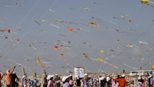 أطفال غزيون يوجهون طائراتهم الورقية على شاطئ غزة 
