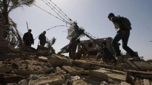 فلسطينيون يتفقدون موقع غارة اسرائيلية في قطاع غزة