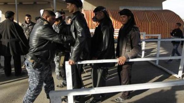 أفراد من الشرطة العراقية يفتشون زوارا من الشيعة في طريقهم الى مدينة كربلاء
