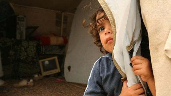 طفل يقف بباب خيمة نصبتها عائلته بعد ان هدمت حماس بيتها/أ.ف.ب