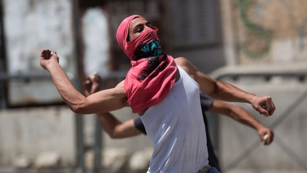 Palestinians throw stones towards Israeli forces during clashes in the West Bank town of Hebron. (AFP/File)