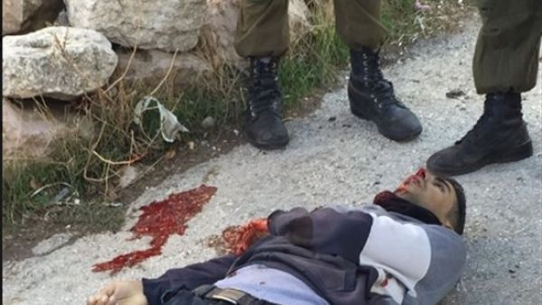 الشهيد ملقى على الارض بعد اطلاق الجنود الاسرائيليين النار عليه