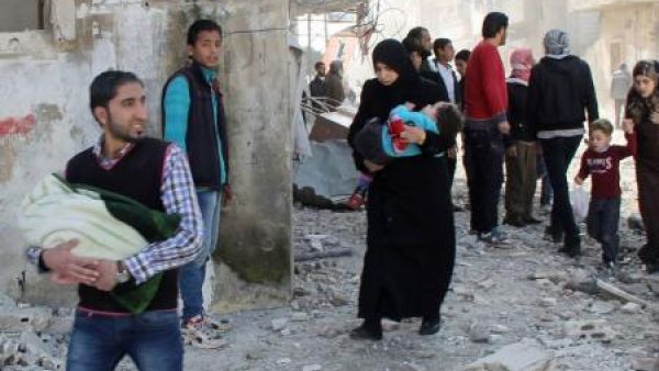 مدنيون يفرون باطفالهم من منطقة تعرضت لقصف من قبل قوات الاسد في حمص
