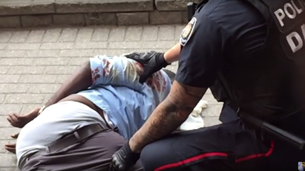 A screenshot from a video uploaded to YouTube shows Abdirahman Abdi on the ground in Ottawa after a violent arrest by police. (YouTube/Islam Muslim) 