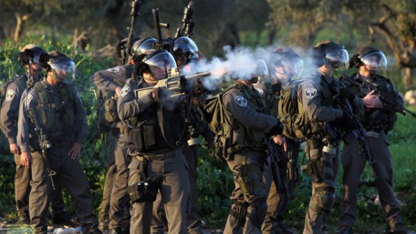 An Israeli security soldier fires a tear gas canister at Palestinian protesters. (AFP/File) An Israeli security soldier fires a tear gas canister at Palestinian protesters. (AFP/File)