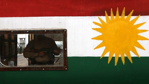 A member of the Iraqi Kurdish Peshmerga forces stands guard in a post bearing the colours of the Kurdish flag in Khazir, near the Kurdish checkpoint of Aski Kalak, 40 kilometres West of Arbil. (AFP/File)
