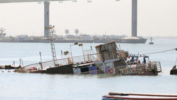 A picture taken in the southeastern Iraqi city of Basra shows a small casino boat that sank in the Shatt al-Arab river after a small device exploded nearby during the night.  (AFP/File)