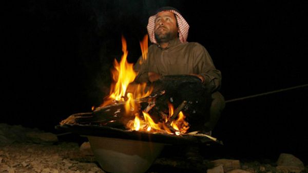 An Iraqi Bedouin sits next to a fire during a traditional wedding ceremony in the desert some 400km from the southern Iraqi city of Samawa. (AFP/File)