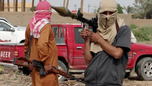 Iraqi armed tribesmen pose for a picture in front of a truck in a road north of Ramadi (Azhar Shallal/AFP)