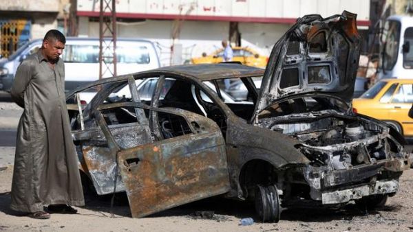 An Iraqi man inspects a burnt-out vehicle at the site of a car bomb explosion in the Hurriyah area of eastern Baghdad (Ahmad Al-Rubaye / AFP)