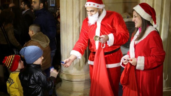 'Santas' hand out chocolates at a Christmas Eve service in Kirkuk, Iraq (Marwan Ibrahim/AFP)