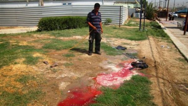 عراقي يغسل دم جنود قتلوا على احد الحواجز ببغداد/ا.ف.ب