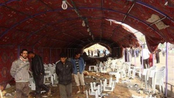 عراقيون يتفقدون موقع سرادق العزاء الذي هاجمه انتحاري في حي الشعلة في بغداد
