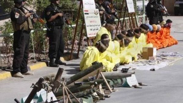 معتقلون معصوبو الاعين يجلسون امام رجال امن عراقيين في البصرة