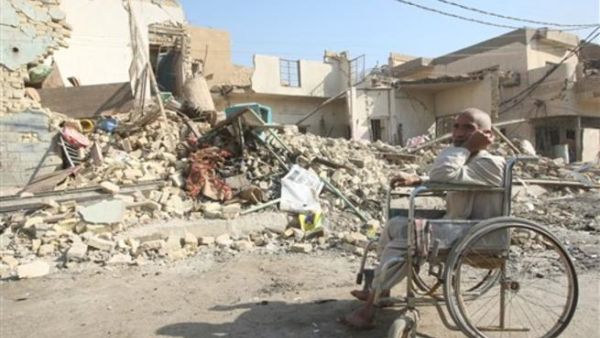 رجل عراقي مقعد الى جوار بيته المهدم/أ.ف.ب