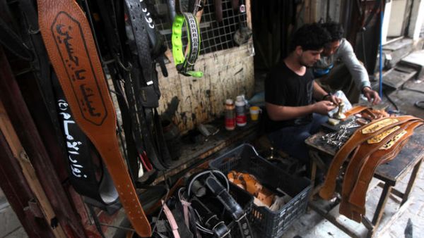 An Iraqi youth makes a belt especially for the annual Shiite Muslim commemoration of Ashura with the saying embossed in Arabic that reads, "Labaik ya Hussein" or " In your service Hussein." (Image credit: AFP)