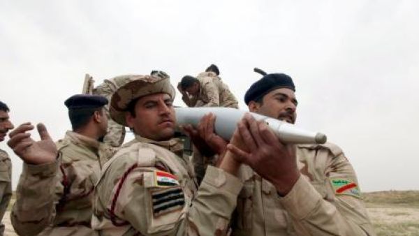 جنود عراقيون يحملون قذيفة اثناء الاشتباكات مع مسلحي الدولة الاسلامية جنوبي الموصل 
