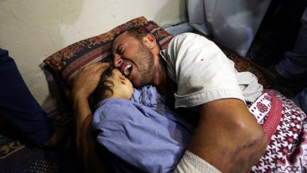 Palestinian father Yehya Hassan mourns while holding the body of his daughter, Rahaf, during a funeral for the toddler and her pregnant mother on Oct. 11, 2015, at the al-Nusairat refugee camp in central Gaza Strip. (AFP/Mahmud Hams)