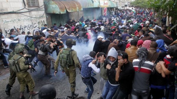Israeli security forces fire tear gas canisters to disperse Palestinian protesters during a demonstration in the occupied West Bank city of Hebron, on Oct. 27, 2015. (AFP/Hazem Bader)