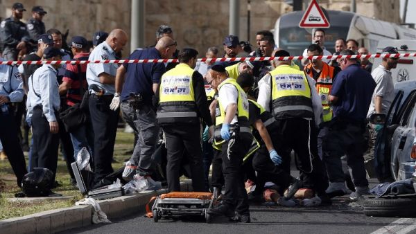Israeli emergency personnel and security forces gather at the scene of an attack outside Jerusalem's Old City's New Gate on March 9, 2016. (AFP/Ahmad Gharabli)