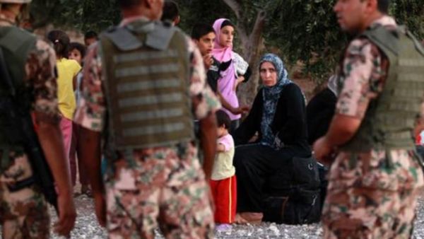 Jordanian soldiers watch over Syrian refugees fleeing violence in their country after they crossed into Jordanian territory with their families from Syria into Jordan. [haaretz]