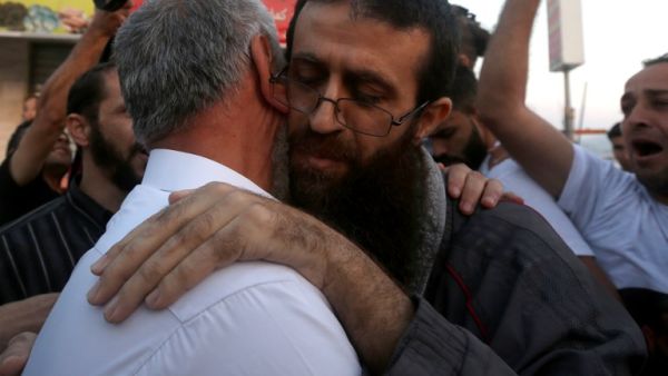 Khader Anan embraces his father after being released from jail, a day before being re-arrested in Old Jerusalem. (AFP/Jaafar Ashtiyeh)