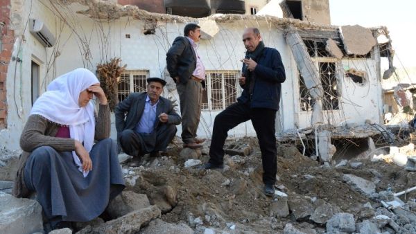 People gather among the rubble of damaged buildings following heavy fighting between government troops and Kurdish fighters in the town of Cizre in southeastern Turkey, near the border with Syria and Iraq, on March 2, 2016. (AFP/Ilyas Akengin)