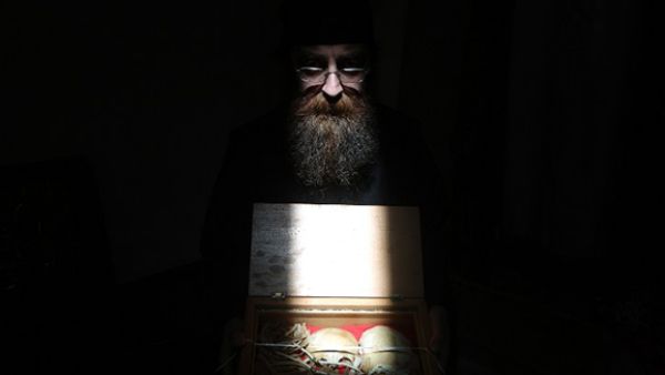 A Greek Orthodox monk holds a box at Our Lady of Hamatoura Monastery in northern Lebanon containing the remains of a boy reportedly killed and found in the ruins of the monastery. (AFP/File)