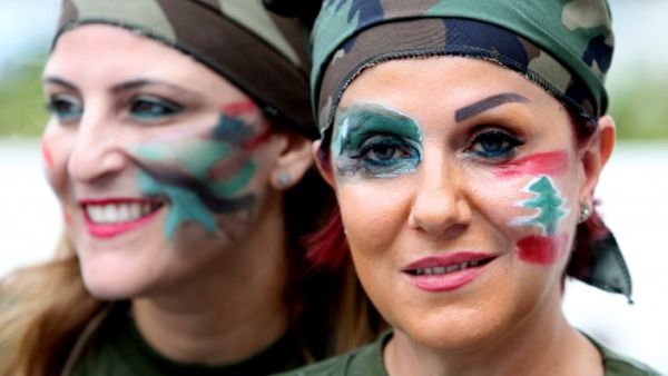 Lebanese women dressed in military fatigue and their faces painted with the colors of their national flag hold a sit in at Martyrs square in downtown Beirut, in support of the Lebanese army, on August 18, 2014. (AFP/Anwar Amro)