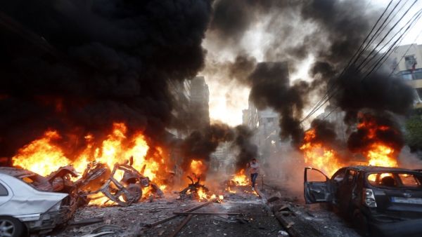 Flames rise from burning cars at the site of a car bomb that targeted Beirut's southern suburb of Haret Hreik on January 2, 2014. [AFP]