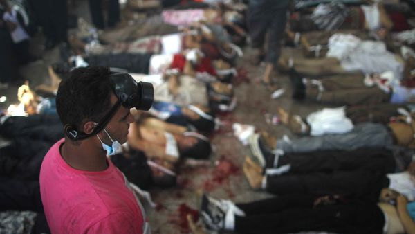 A man looks at bodies laid out in a make shift morgue after Egyptian security forces stormed two huge protest camps at the Rabaa al-Adawiya and Al-Nahda squares where supporters of ousted president Mohamed Morsi were camped (AFP/MOSAAB EL-SHAMY)