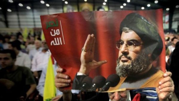 رجل يحمل صورة للامين العام لحزب الله خلال مشاركته في احتفال بمناسبة "يوم شهيد حزب الله"