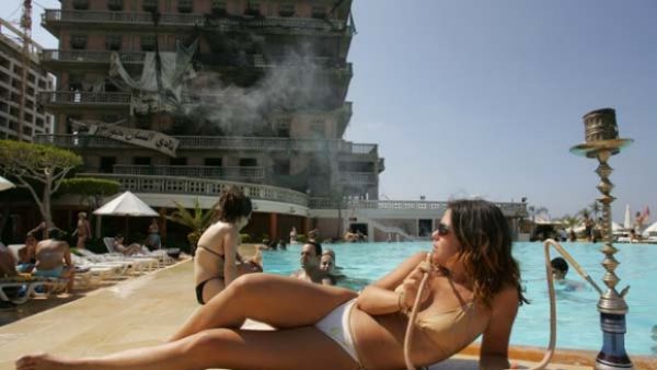 Visitors enjoy the swimming pool of Beirut's bombed landmark Saint-George Hotel. (AFP/File)