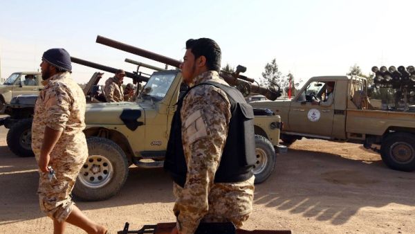 Armed fighters loyal to the Fajr Libya (Libya Dawn), an alliance of Islamist-backed militias, walk next to their vehicles on March 15, 2015 in Libya's coastal city of Sirte. (AFP/File)